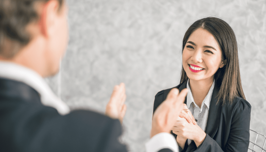 Women smiling while man congratulatorily claps in front of her