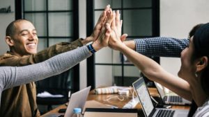 Peer recognition moment being displayed as a high five over employees desks