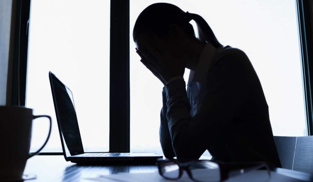 Upset employee sitting in front of laptop looking at employee assistance programs