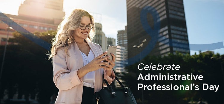 Administrative Professional walking in the city using her phone