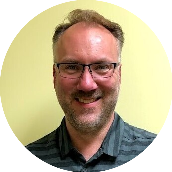 Round headshot of a man in glasses with a yellow background