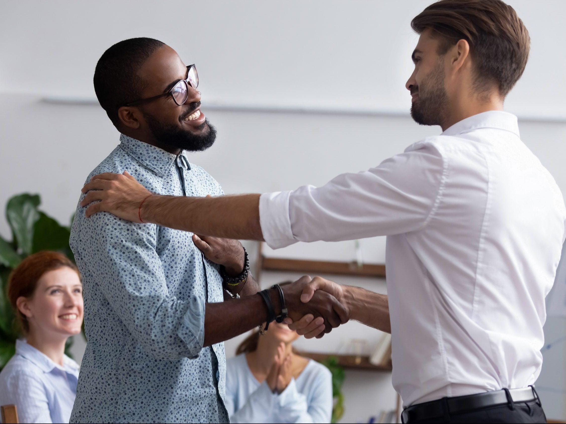 Diverse,People,Gathered,In,Meeting,Executive,Manager,Shake,Hands,With Two men shaking hands