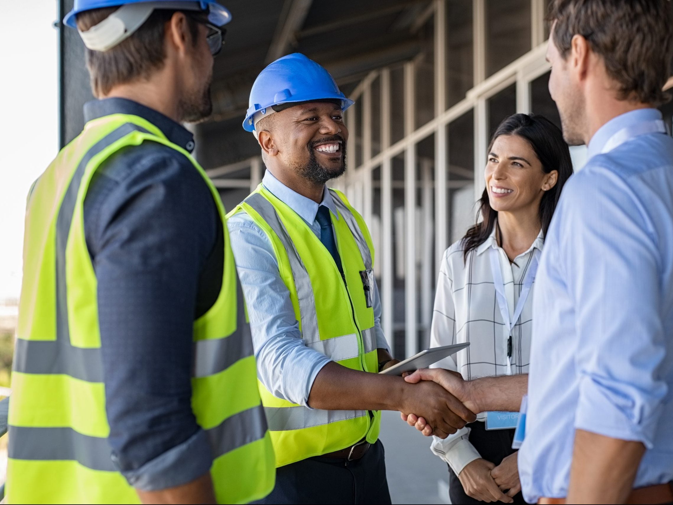 Smiling,Engineer,Shaking,Hands,At,Construction,Site,With,Happy,Architect.