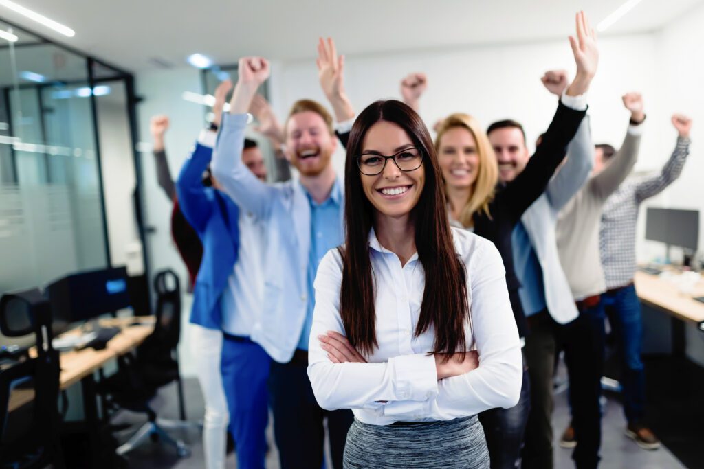 Successful team of young perspective businesspeople posing in office