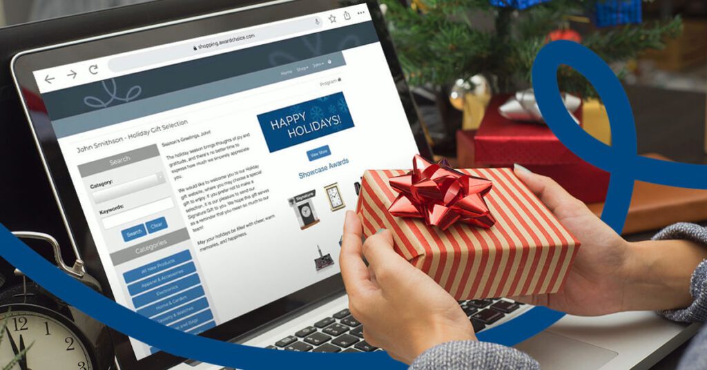 Employee holding holiday gift facing computer