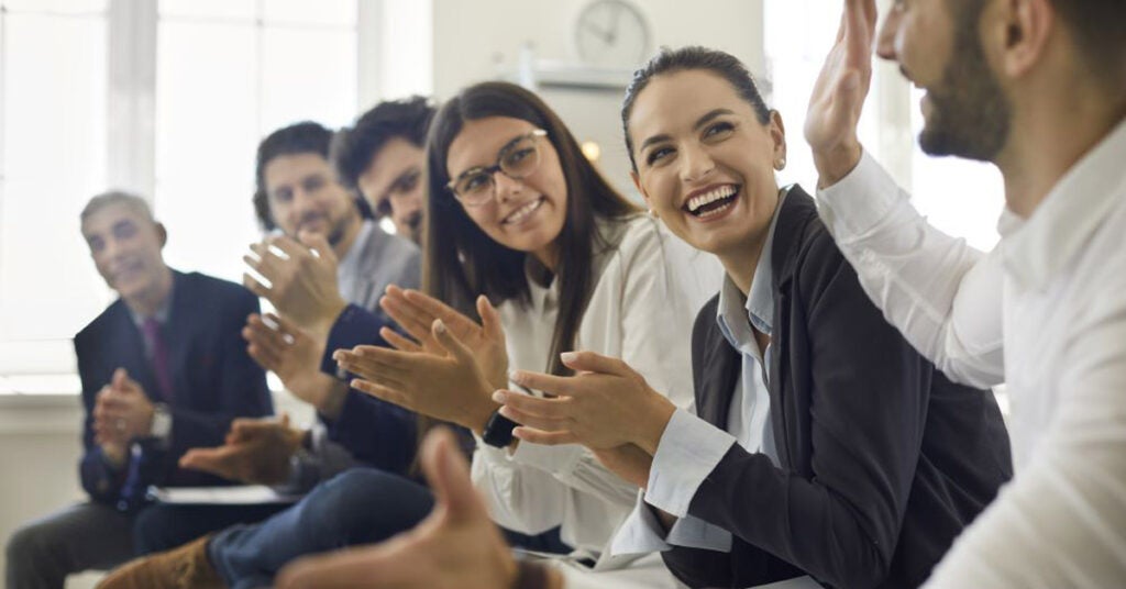 Gender inclusive employees applauding each other
