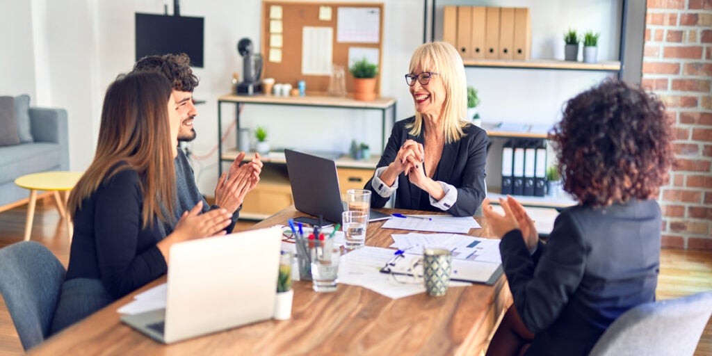 Employees discuss employee engagement during meeting at table