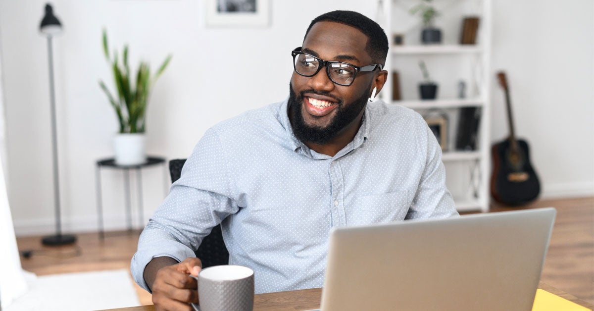 Man with glasses in home office with coffee cup