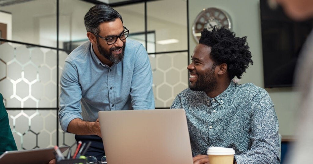 Two happy men receiving employee recognition on a laptop