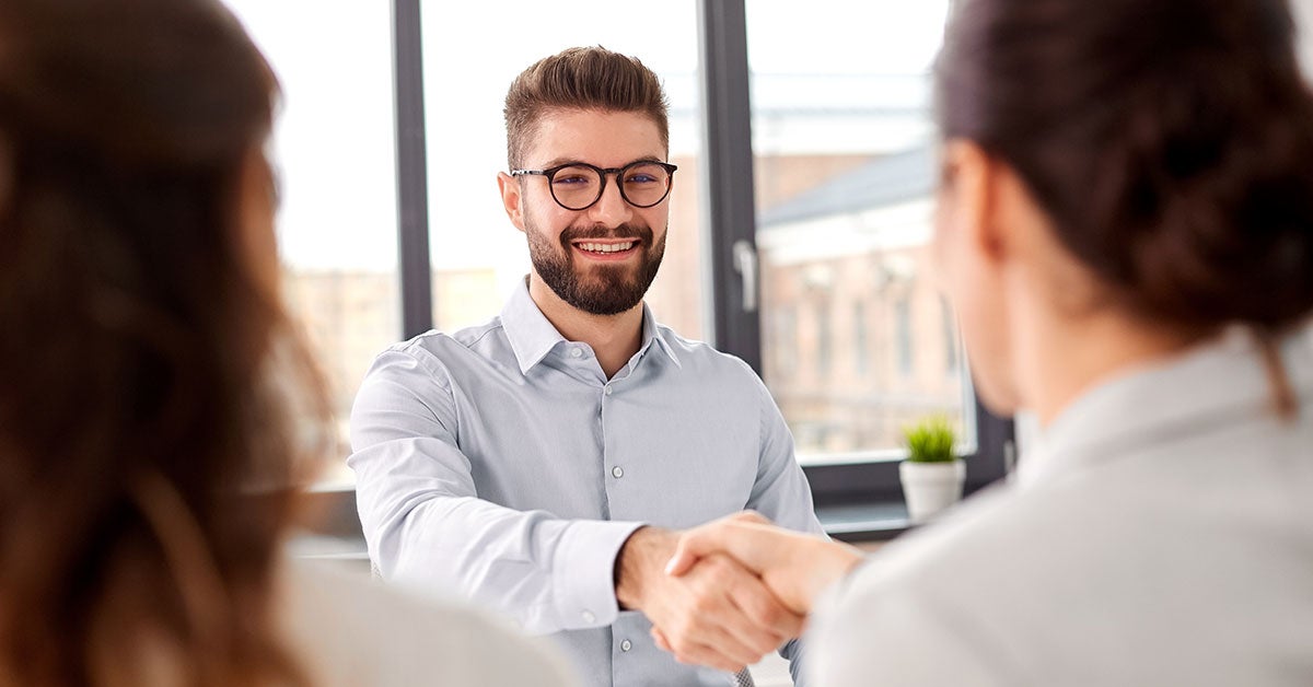 Man with glasses shaking hands with woman