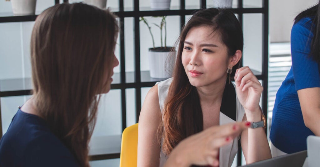 Two women meeting, looking focused