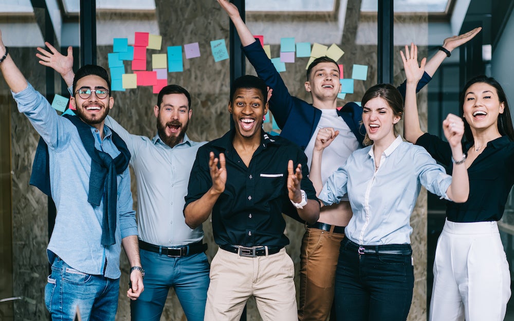 Young crew of happy excited male and female business partners celebrating completed startup project while looking at camera and laughing, overjoyed colleagues feeling amazed of done good work Young crew of happy excited male and female business partners celebrating completed startup project while looking at camera and laughing, overjoyed colleagues feeling amazed of done good work