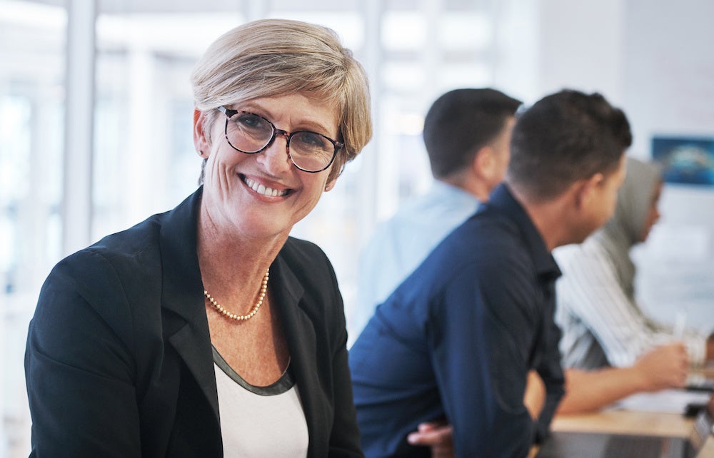 Portrait of a mature businesswoman having a meeting with colleagues in a modern office