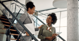 a boss and employee chatting on a staircase