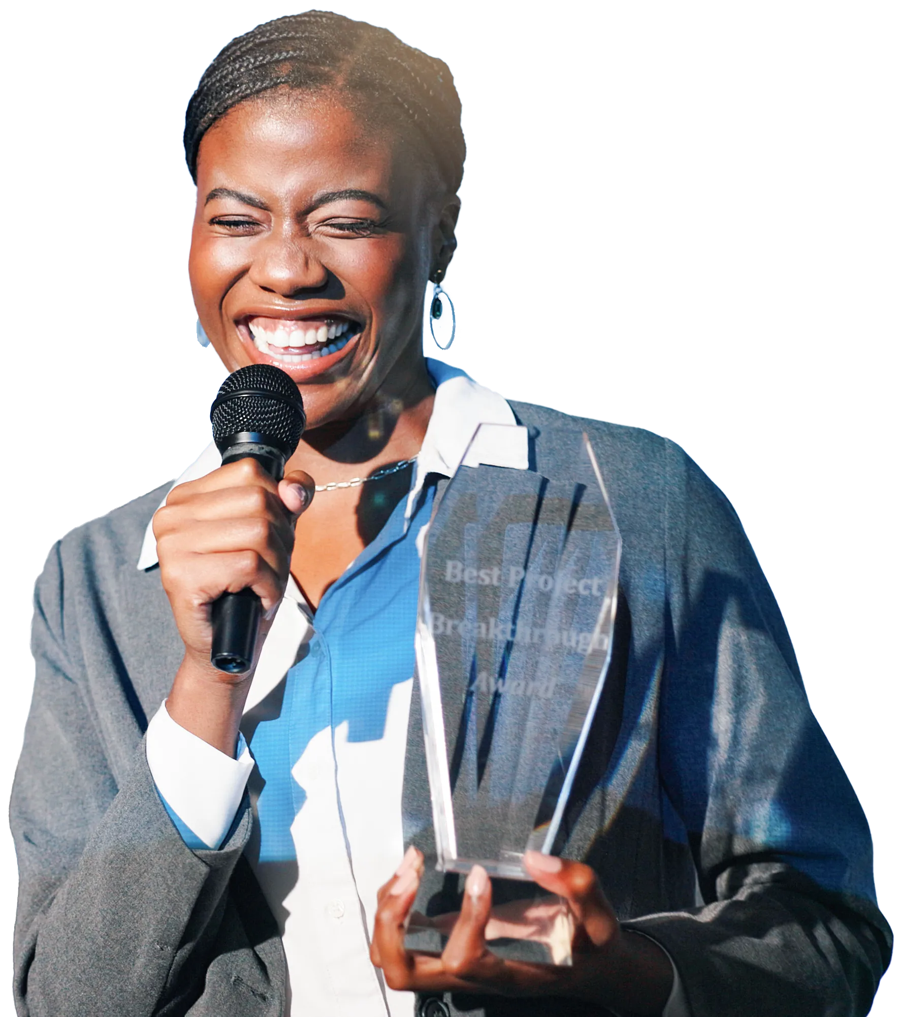 A woman with braids in a business outfit is smiling while holding an award and a microphone.