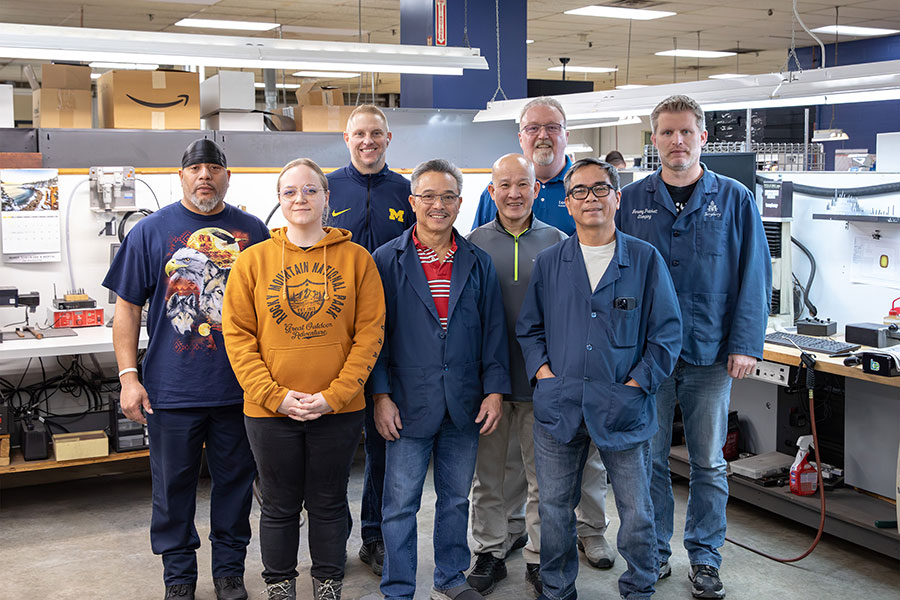 A group of men stand on a factory floor