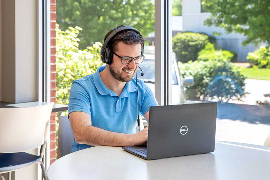 A man sitting in a coffee shop remote working on his computer