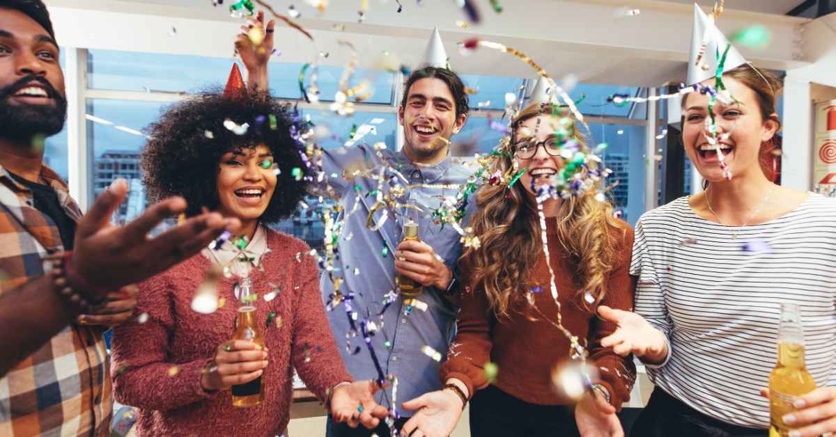 group of employees celebrating at office party, confetti falling