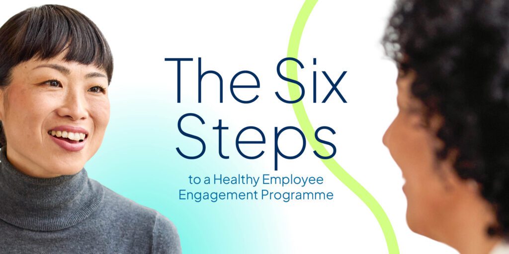 A smiling Asian woman in a grey turtleneck listening attentively to a colleague in a workplace setting, alongside blue and teal text that reads: "The Six Steps to a Healthy Employee Engagement Programme".