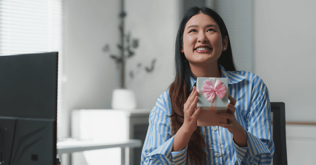 happy woman at desk with gift box