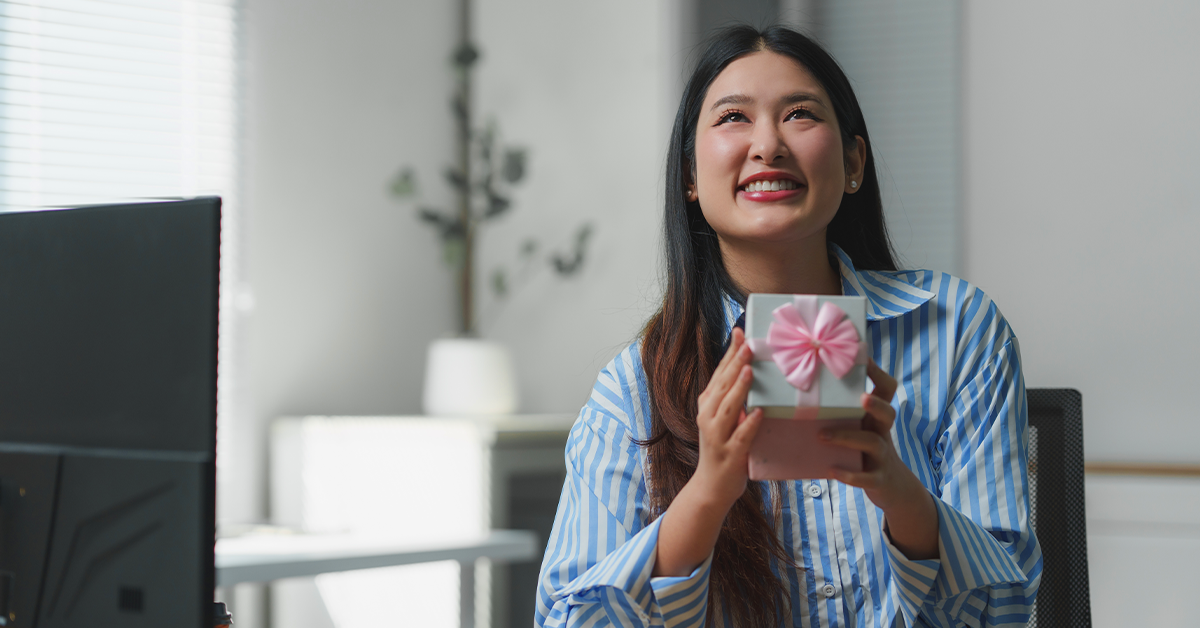 happy woman at desk with gift box