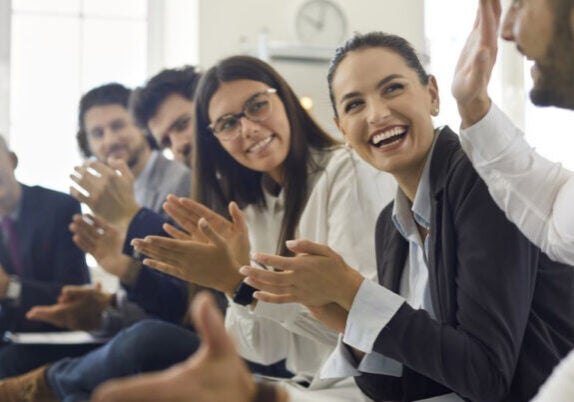 Gender inclusive employees applauding each other