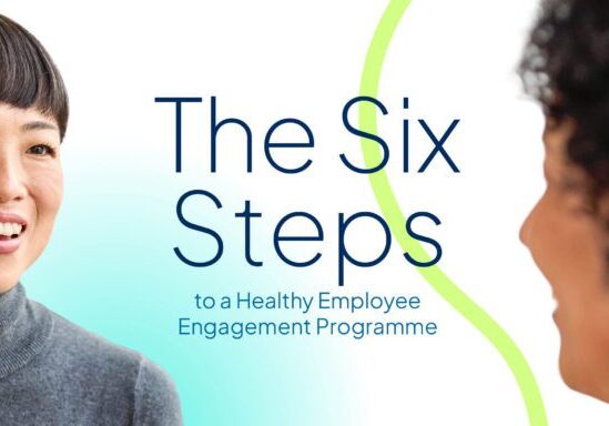 A smiling Asian woman in a grey turtleneck listening attentively to a colleague in a workplace setting, alongside blue and teal text that reads: "The Six Steps to a Healthy Employee Engagement Programme".