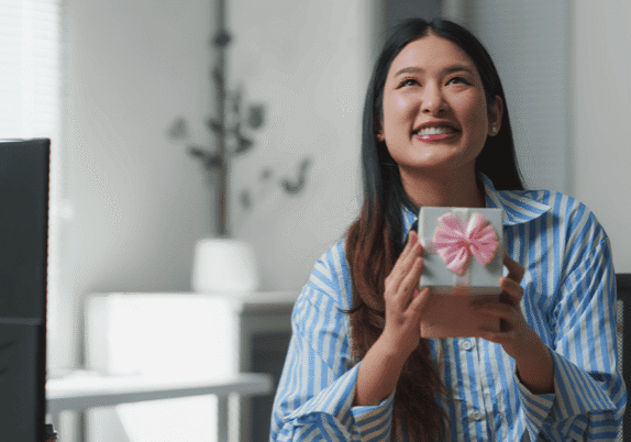 happy woman at desk with gift box